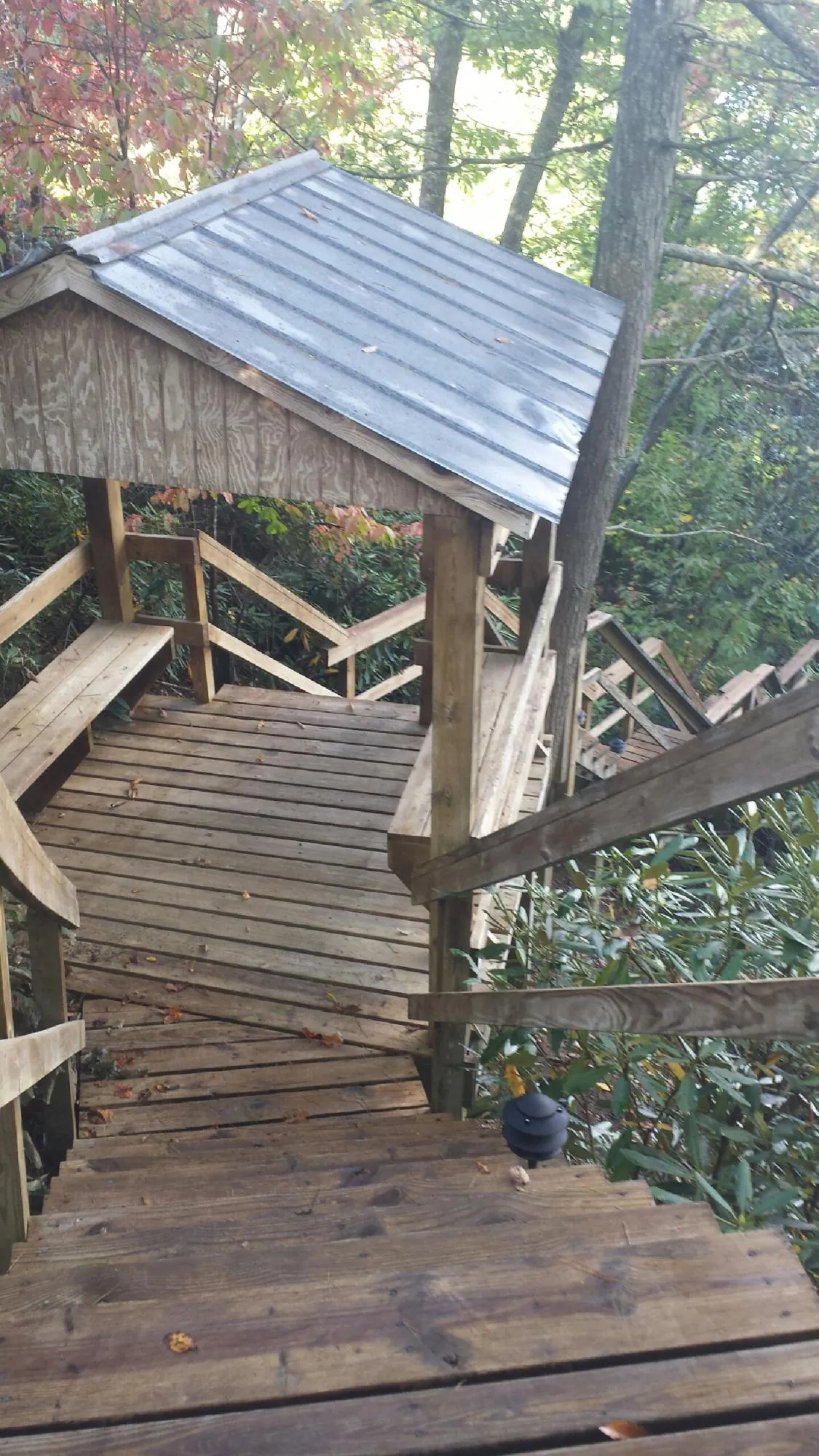 Metal roofed shelter over wooden steps on a wooded walkway — Skylight Repair & Installation work by our crew in Mount Aetna