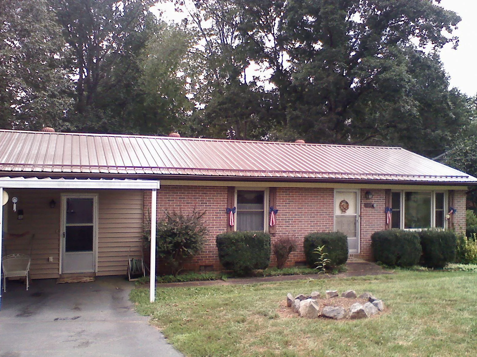 Bronze metal roof and carport on a brick ranch home — Roof Repair work by our crew in Mount Aetna